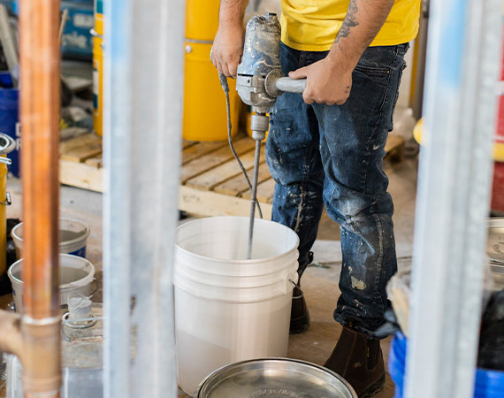 Concrete experts mixing decorative epoxy floor coating.